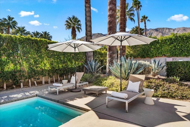 view of pool with a patio and a mountain view