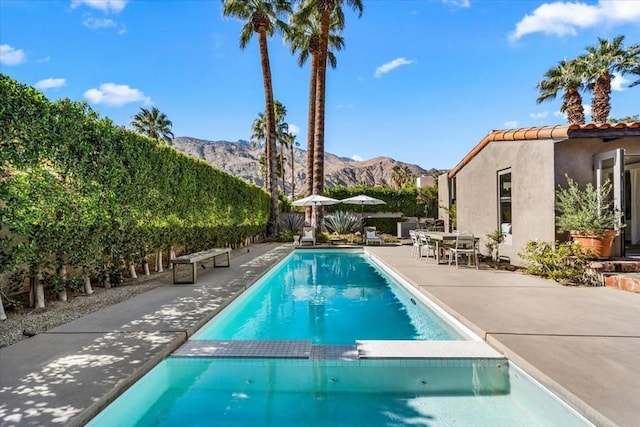 view of pool with a mountain view and a patio area