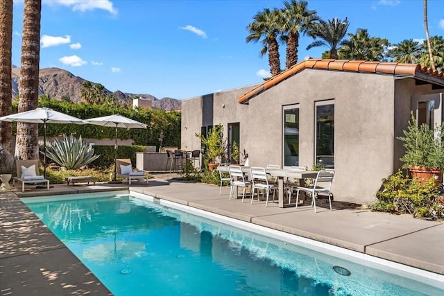 view of swimming pool with a mountain view and a patio area