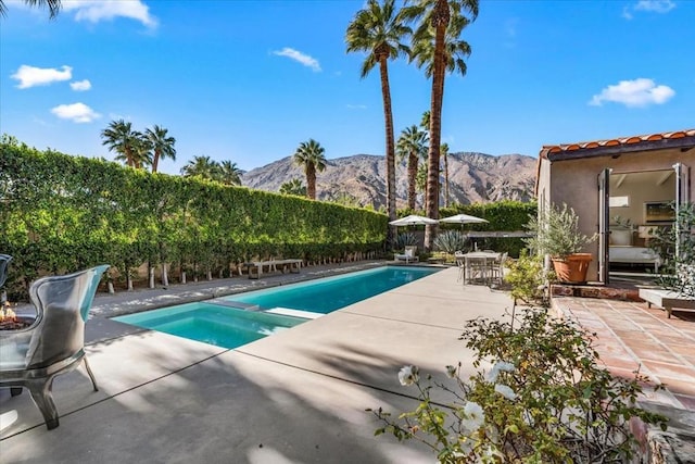 view of swimming pool with a patio and a mountain view