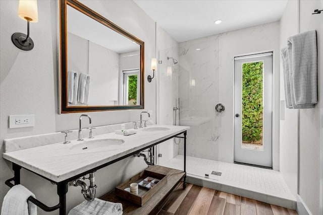 bathroom featuring dual sinks and walk in shower