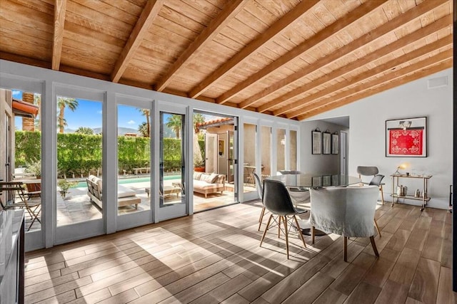 unfurnished sunroom featuring a healthy amount of sunlight, lofted ceiling with beams, and wooden ceiling