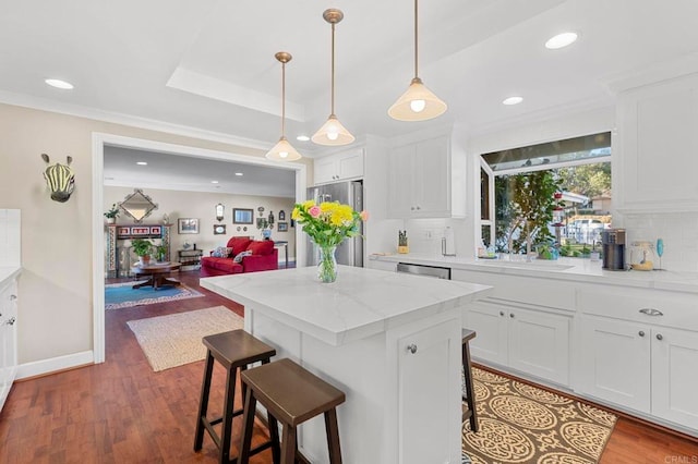 kitchen featuring stainless steel appliances, white cabinetry, sink, and a kitchen breakfast bar