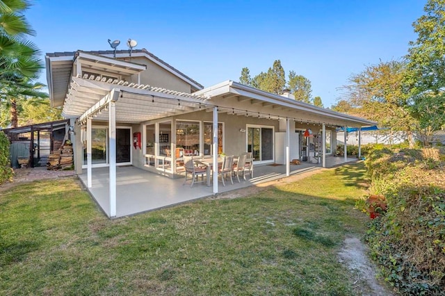 rear view of house with a pergola, a lawn, and a patio area