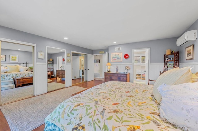 bedroom with hardwood / wood-style flooring and a wall unit AC