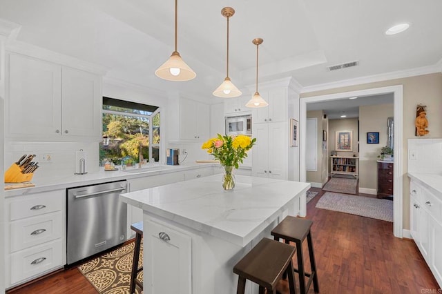 kitchen featuring a breakfast bar area, a kitchen island, white cabinets, stainless steel appliances, and backsplash