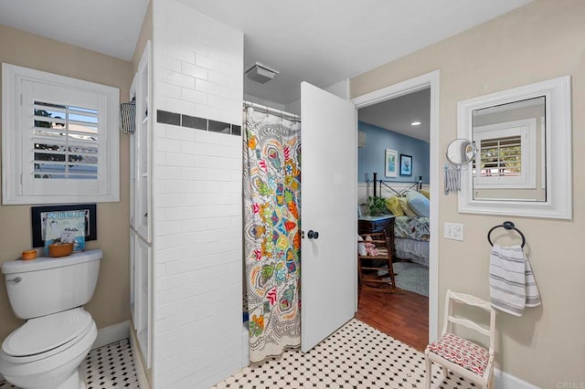 ensuite bathroom featuring toilet, ensuite bath, baseboards, and a tile shower