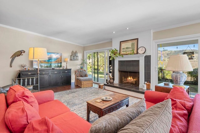 living area with recessed lighting, wood finished floors, crown molding, and a tile fireplace