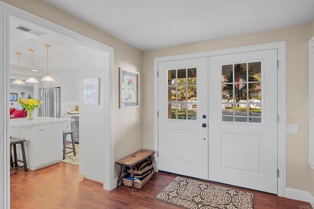 foyer featuring french doors, visible vents, baseboards, and dark wood-style flooring