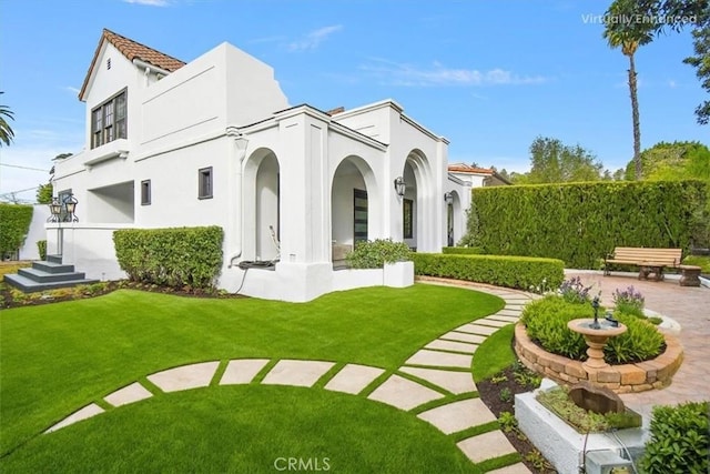 exterior space featuring a patio area and a front lawn