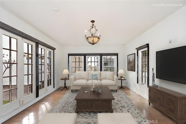 living room with a notable chandelier and light hardwood / wood-style floors