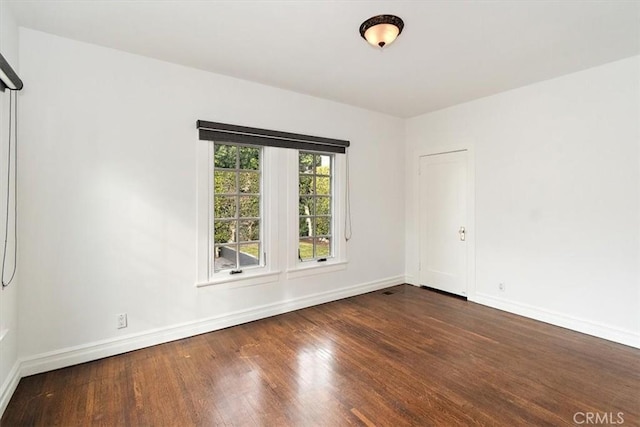 spare room with dark wood-type flooring