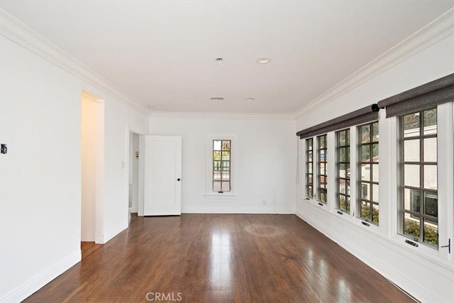 spare room featuring ornamental molding and dark hardwood / wood-style floors