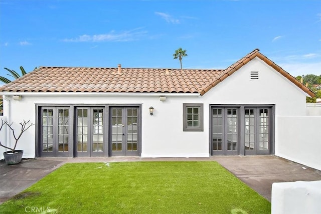 rear view of house with a yard and french doors