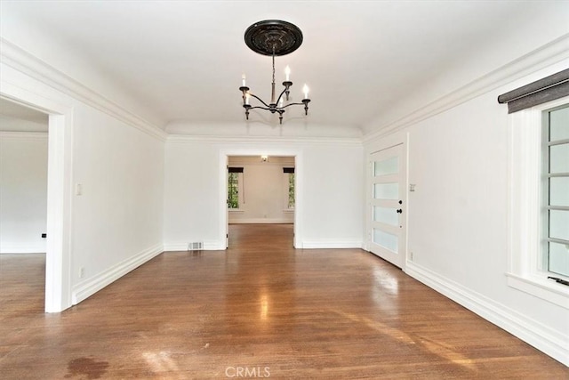 unfurnished dining area with crown molding, dark hardwood / wood-style floors, and a chandelier