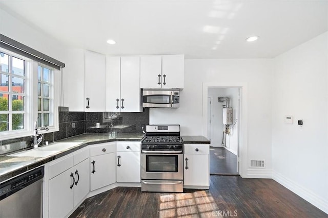 kitchen with white cabinetry, appliances with stainless steel finishes, and dark wood-type flooring