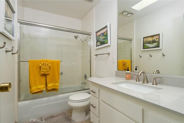 full bathroom with toilet, vanity, and bath / shower combo with glass door