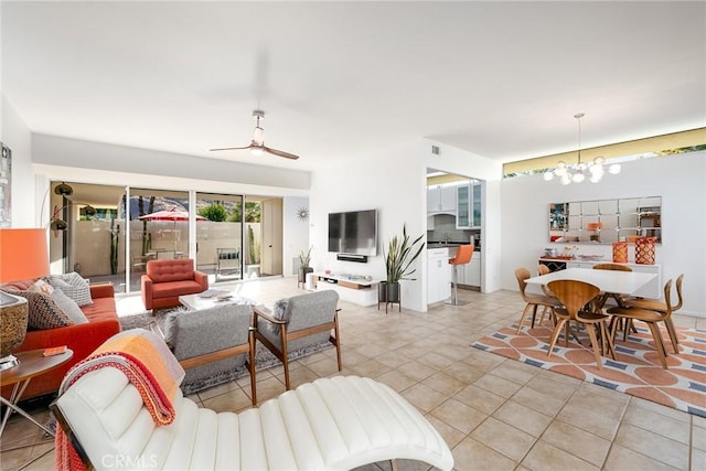 tiled living room featuring ceiling fan with notable chandelier