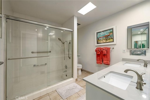 bathroom featuring tile patterned flooring, vanity, walk in shower, and toilet