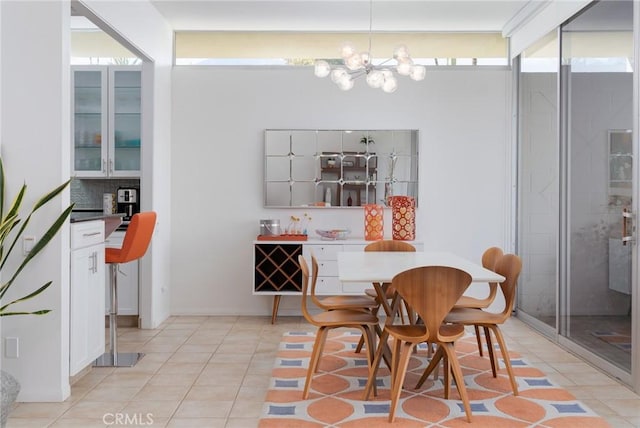 tiled dining room with an inviting chandelier