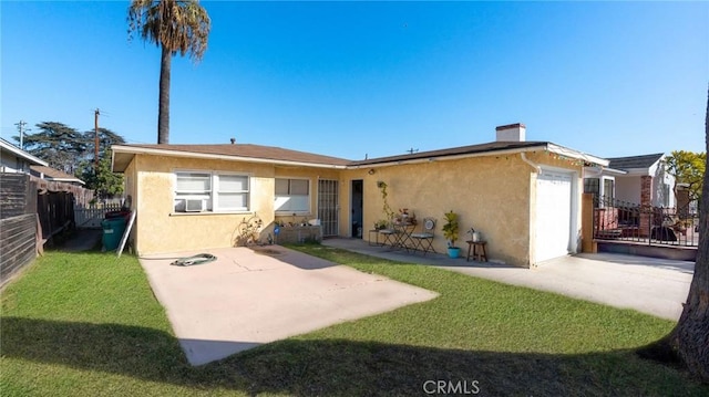 back of property featuring a yard, a patio, and a garage