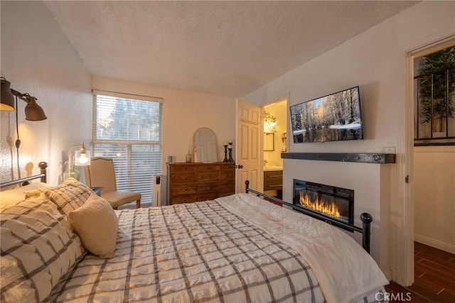 bedroom with a textured ceiling and ensuite bathroom