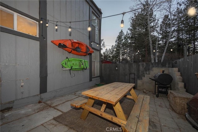 patio terrace at dusk featuring grilling area