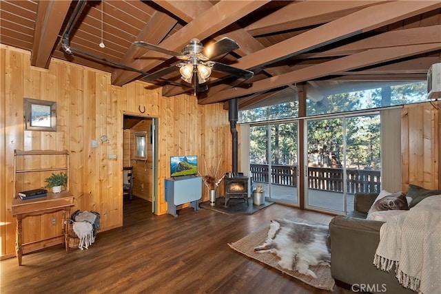 living room featuring track lighting, lofted ceiling with beams, hardwood / wood-style floors, and a wood stove