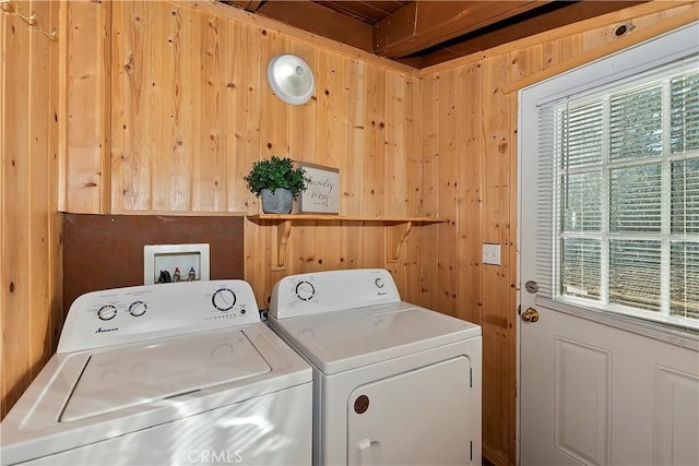 washroom with plenty of natural light, independent washer and dryer, and wood walls