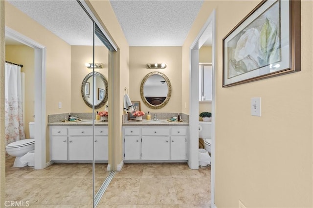 bathroom with vanity, toilet, and a textured ceiling