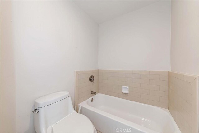 bathroom featuring a tub and toilet