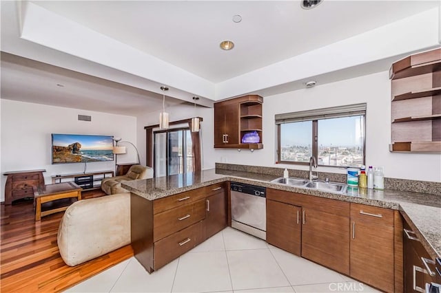 kitchen with sink, stainless steel dishwasher, kitchen peninsula, pendant lighting, and dark stone counters