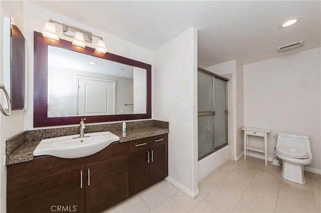 full bathroom featuring toilet, vanity, shower / bath combination with glass door, and tile patterned flooring