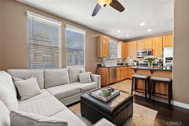 living room with light hardwood / wood-style flooring and ceiling fan