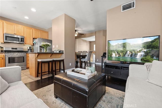 living room with light hardwood / wood-style floors and ceiling fan