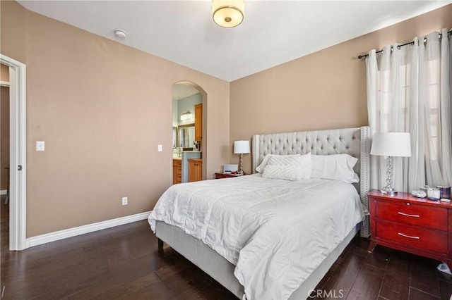 bedroom with dark wood-type flooring and ensuite bath