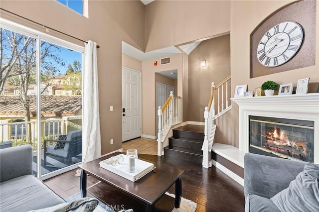 living room featuring dark hardwood / wood-style floors and a towering ceiling