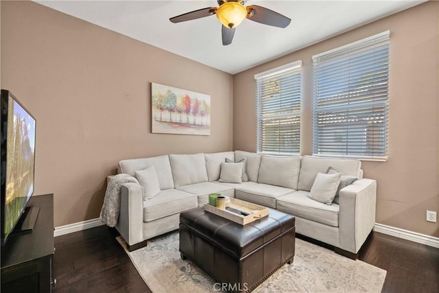 living room featuring dark wood-type flooring and ceiling fan