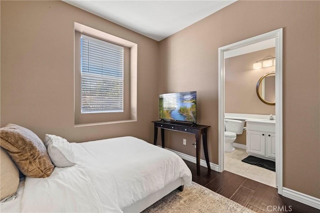 bedroom with dark hardwood / wood-style floors and ensuite bath