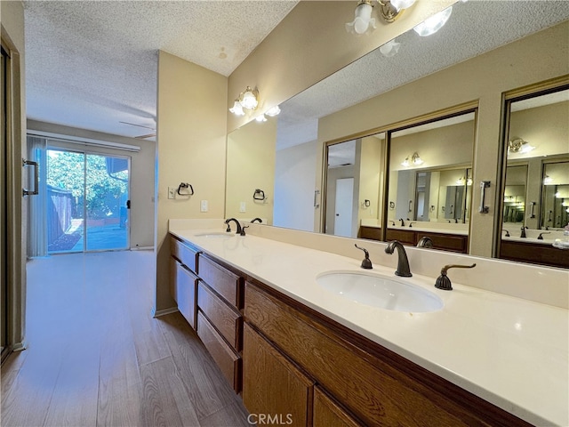 bathroom with vanity, wood-type flooring, and a textured ceiling