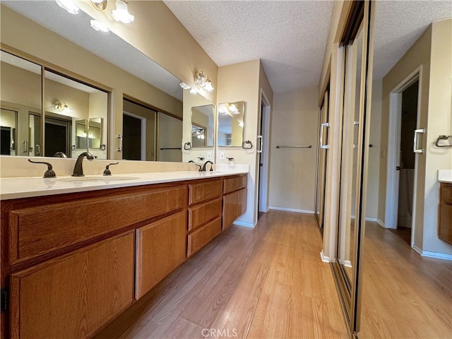 bathroom with hardwood / wood-style flooring, vanity, and a textured ceiling