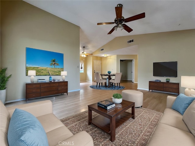 living room featuring vaulted ceiling, light hardwood / wood-style floors, and ceiling fan