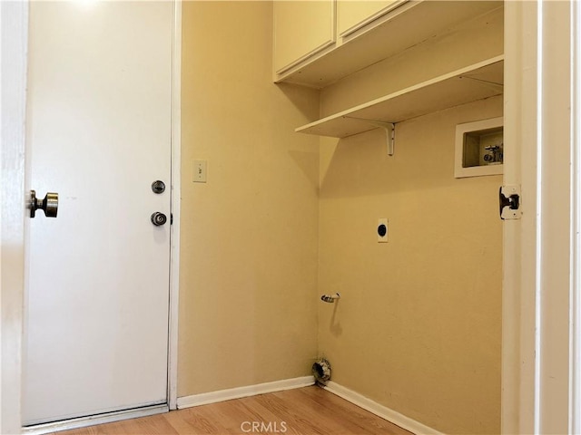 laundry area featuring cabinets, washer hookup, hookup for an electric dryer, and light hardwood / wood-style flooring