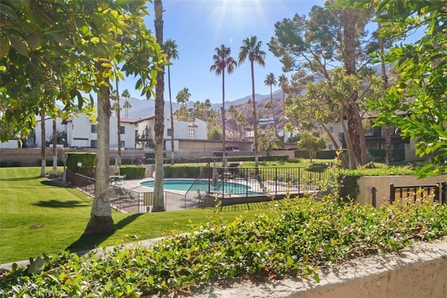 view of swimming pool featuring a mountain view and a lawn