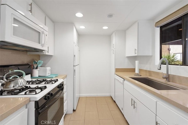 kitchen featuring white cabinetry, sink, and white appliances