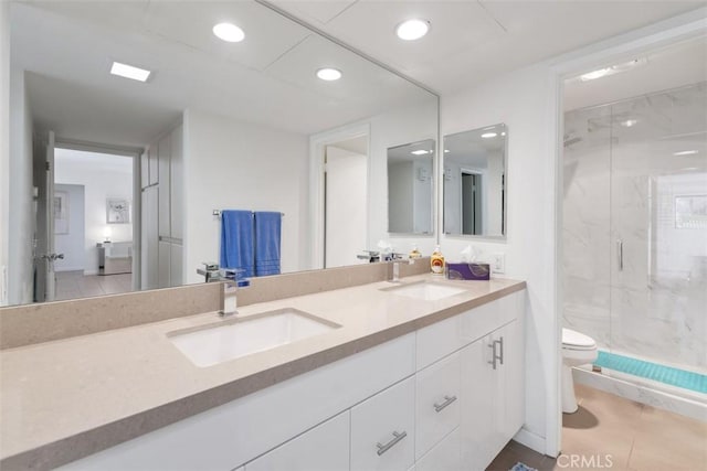 bathroom featuring vanity, toilet, a shower with shower door, and tile patterned flooring