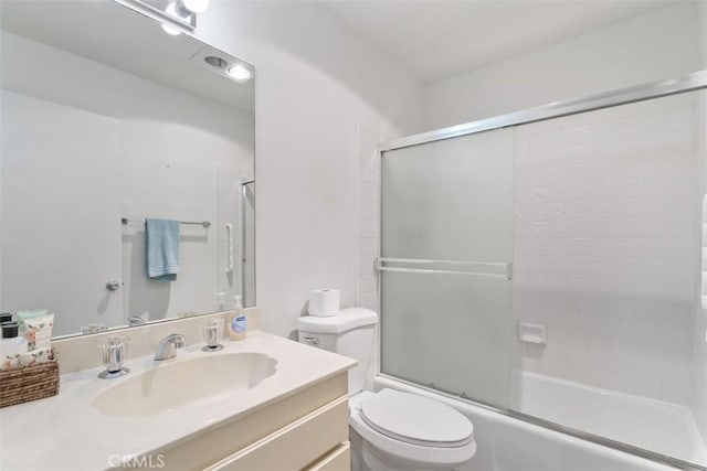 full bathroom featuring shower / bath combination with glass door, vanity, and toilet