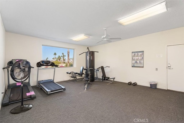 exercise area featuring ceiling fan and a textured ceiling