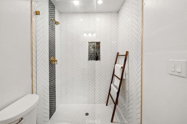 full bath featuring tiled shower and toilet