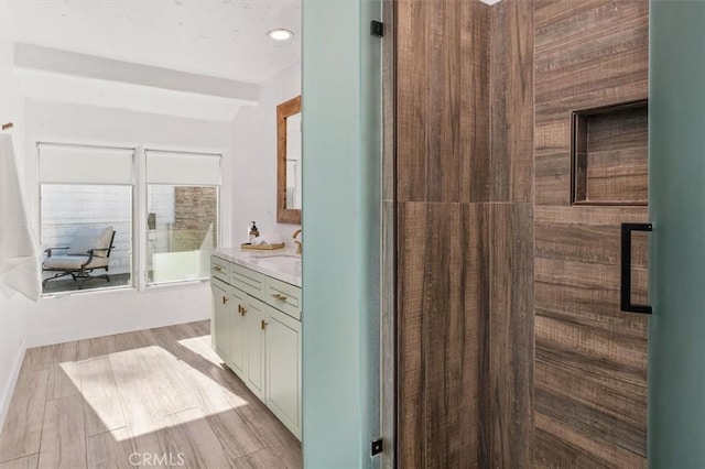 full bath with an enclosed shower, vanity, and wood tiled floor